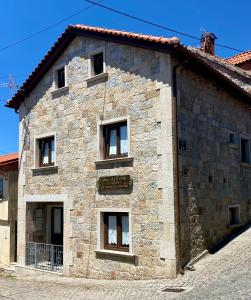 朱尼亞斯皮唐斯的住宿－Casa da Fonte，一座石头建筑,上面有标志