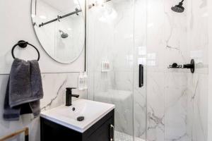 a white bathroom with a sink and a shower at Walk to Bathhouses, Restaurants, Heart of Downtown, Room # 303 in Hot Springs