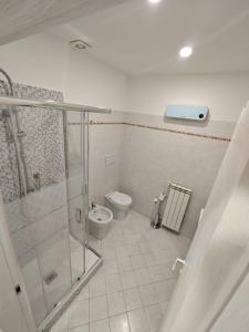 y baño con ducha de cristal y aseo. en Ca' Barabino en Génova