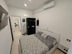 biała sypialnia z łóżkiem i telewizorem w obiekcie Ca' Barabino w Genui