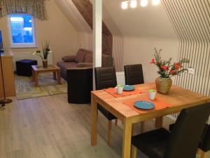 a living room with a wooden table and a dining room at Ferienwohnung Hellerling in Ilsenburg