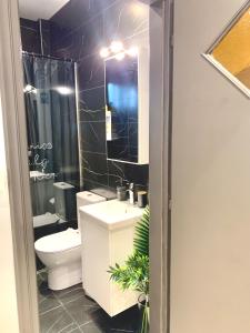 Un baño con inodoro, lavabo y espejo. en River Tales 4, en Kalamata