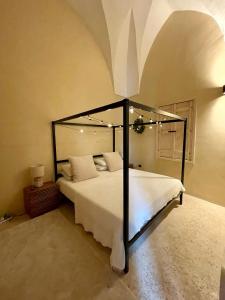 a bedroom with a large white bed with a black frame at Corte Dei Sogni Bed & Breakfast in San Pietro in Lama +21 photos