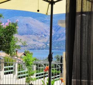 - Balcón con sombrilla y vistas a la montaña en Casa Luminosa Guesthouse, en Lixouri