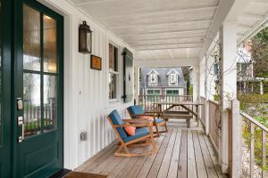 un portico con due sedie e un tavolo di Cedarbrook Cottage by Seabrook Hospitality a Pacific Beach
