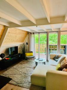 Una sala de estar con un sofá y un televisor. en Barbuy - Natuurhuisje in Durbuy - Bar - Zwem - Ontspan, en Durbuy