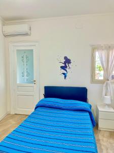 a bedroom with a bed with a blue comforter at Il mare di Ognina in Siracusa