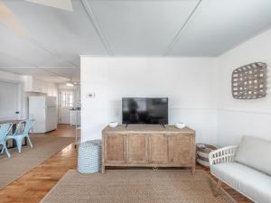 a living room with a couch and a flat screen tv at Mountains to Sea in Topsail Beach