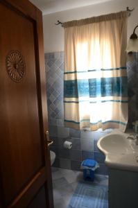 a bathroom with a sink and a toilet and a window at Casa vista mare in San Teodoro