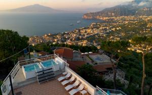 a house with a swimming pool and a view of the water at Hotel Villa Fiorita in Sorrento