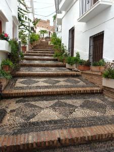 Un conjunto de escaleras de ladrillo que conducen a un edificio. en Casa Naomi, en Álora