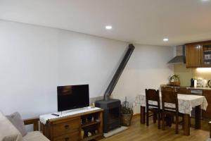 a living room with a table with a computer on it at Casa da Fonte in Pitões das Júnias