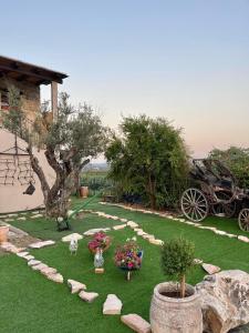 un jardín con un carruaje y flores en el césped en בוסתן החורש en Haifa