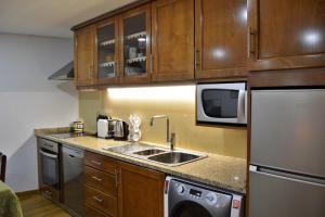 a small kitchen with a sink and a refrigerator at Casa da Fonte in Pitões das Júnias