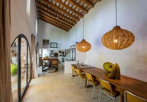 a dining room with a long wooden table and chairs at Masia Vilatersana in Sant Llorenc Savall