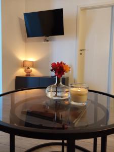 a glass table with a candle and a vase of flowers at Apartment Paola - Šibenik in Šibenik