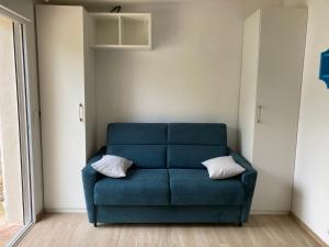 a blue couch with two pillows in a room at studio maisonnette de vacances in Cannes