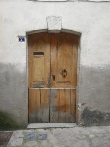 uma porta de madeira no lado de um edifício em Studio de charme avec vue, en plein coeur de Florac em Florac