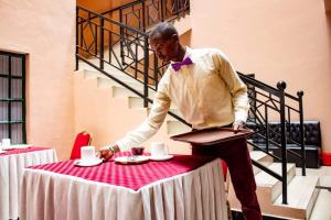 un uomo in piedi a un tavolo con una tovaglia di Hummingcage a Nairobi
