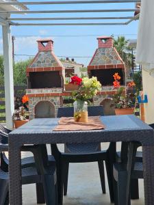 a table with chairs and a fireplace on a patio at EFI APARTMENTS in Fanari +15 photos