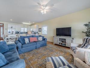 een woonkamer met blauwe banken en een flatscreen-tv bij Ocean Splendor in Surf City