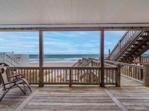 een terras met een bank en een trap naar het strand bij Ocean Splendor in Surf City