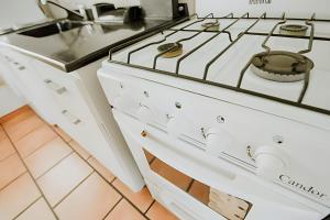 - une cuisine équipée de plaques de cuisson blanches dans l'établissement Lindo apartamento centrico y cómodo, à Ushuaia