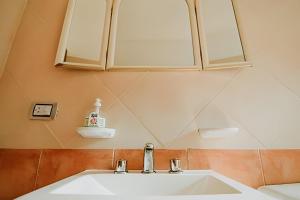La salle de bains est pourvue d'un lavabo blanc et d'une armoire. dans l'établissement Lindo apartamento centrico y cómodo, à Ushuaia