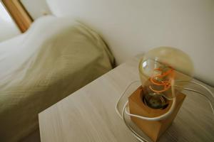 un vase en verre sur une table à côté d'un lit dans l'établissement Lindo apartamento centrico y cómodo, à Ushuaia