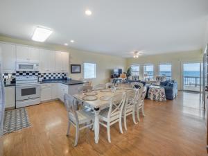 een keuken en woonkamer met een tafel en stoelen bij Ocean Splendor in Surf City +86 foto's