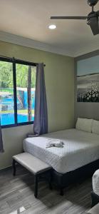um quarto com uma cama grande e uma janela em Mi Tierra Hotel y Restaurante em San Luis