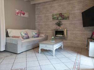 a living room with a couch and a fireplace at Gite et Studio "L'éclosion des Papillons" à 10 kms de Lens in Courrières