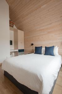 a bedroom with a large white bed with blue pillows at Le Chalet Waterfront Retreat in Ucluelet