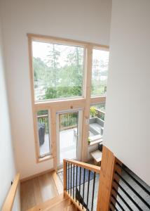 an empty room with two windows and a staircase at Le Chalet Waterfront Retreat in Ucluelet