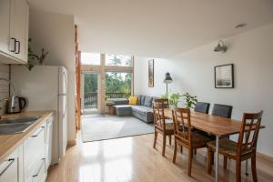 a kitchen and living room with a table and chairs at Le Chalet Waterfront Retreat in Ucluelet
