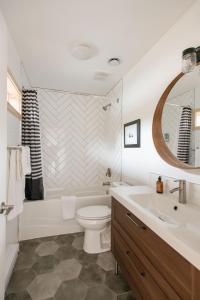 a bathroom with a tub and a toilet and a sink at Le Chalet Waterfront Retreat in Ucluelet
