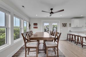 une cuisine et une salle à manger avec une table et des chaises en bois dans l'établissement Oceanwatch Cottage, à Surf City 39 autres photos