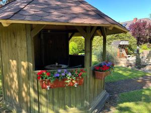 a gazebo with two flower pots and a roof at Ferienhaus Wieke in Wiesmoor