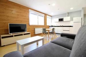 A television and/or entertainment centre at ALQUILAZ Apartamentos Turísticos