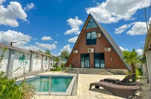 une maison en forme de triangle avec une piscine dans l'établissement Qafqaz Mountain Chalet, à Qabala