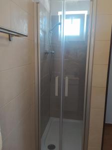 una doccia con una porta in vetro in un bagno di Casa Pereira a Vila Nova de Milfontes