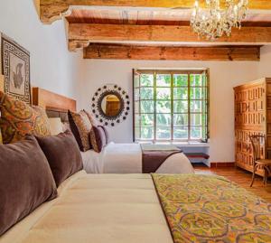 uma sala de estar com uma cama grande e um lustre em Molino de los Reyes By Rotamundos em Totolac