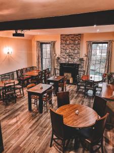 een restaurant met tafels en stoelen en een open haard bij The Ironmaster in Broseley