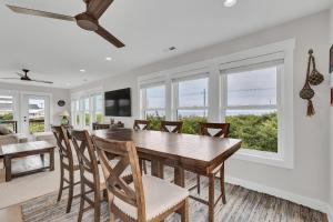 une salle à manger avec une table et des chaises dans l'établissement Oceanwatch Cottage, à Surf City