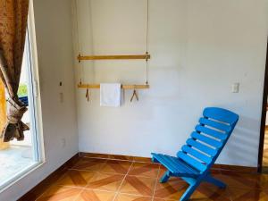 a blue chair sitting in a room with a window at Casa Karma in Puerto Escondido