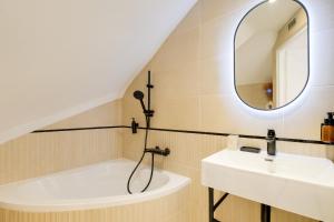 a bathroom with a sink and a tub and a mirror at Vauban, Notre Dame de la Garde, 3 chambres, terrasse, jacuzzi in Marseille