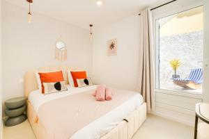 a bedroom with a bed with pink shoes on it at Vauban, Notre Dame de la Garde, 3 chambres, terrasse, jacuzzi in Marseille