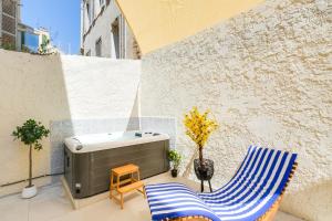 a hot tub and two chairs on a patio at Vauban, Notre Dame de la Garde, 3 chambres, terrasse, jacuzzi in Marseille