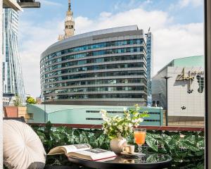 ワルシャワにあるGold Premium 2-bedroom Suite 100m from Central Station, modern&high standardのバルコニーに本とドリンクを用意したテーブル