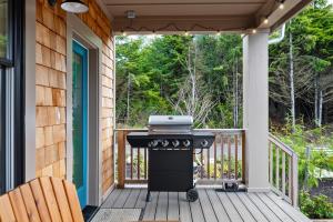ein Grill auf einer abgeschirmten Veranda an einem Haus in der Unterkunft Beach Hair Don't Care by Seabrook Hospitality in Pacific Beach